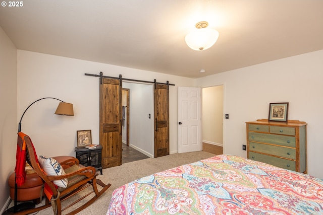 carpeted bedroom with a barn door and baseboards