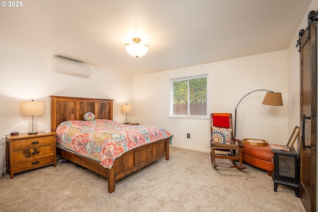 bedroom featuring a barn door, light carpet, a wall mounted AC, and baseboards