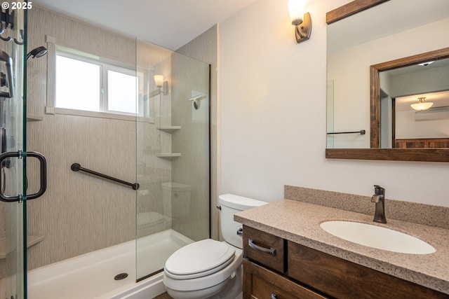 bathroom featuring toilet, a stall shower, and vanity
