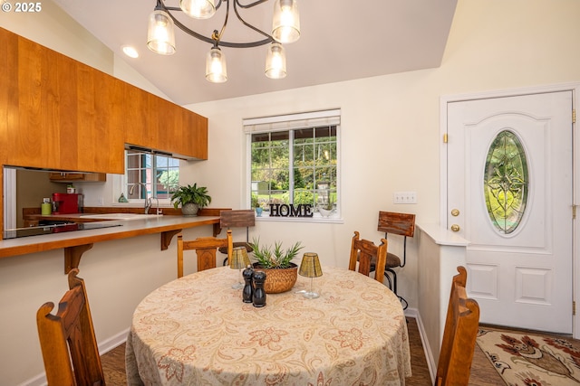 dining space with vaulted ceiling, wood finished floors, and baseboards