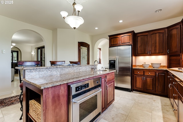 27161 Briggs Hill Rd, Eugene, OR 97405 - kitchen featuring stainless steel appliances, a sink, arched walkways, a center island with sink, and recessed lighting
