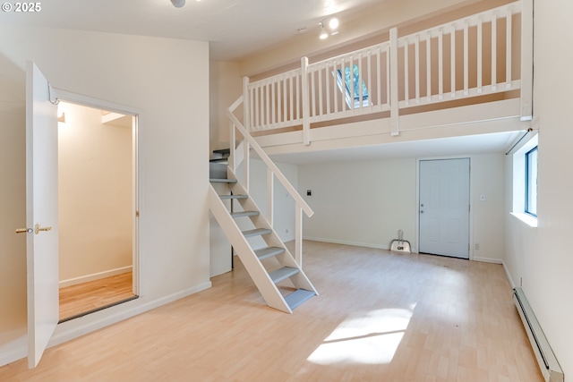 27161 Briggs Hill Rd, Eugene, OR 97405 - stairway with a baseboard heating unit, wood finished floors, baseboards, and a towering ceiling