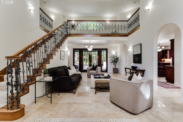 27161 Briggs Hill Rd, Eugene, OR 97405 - living area with arched walkways, a high ceiling, french doors, baseboards, and stairs