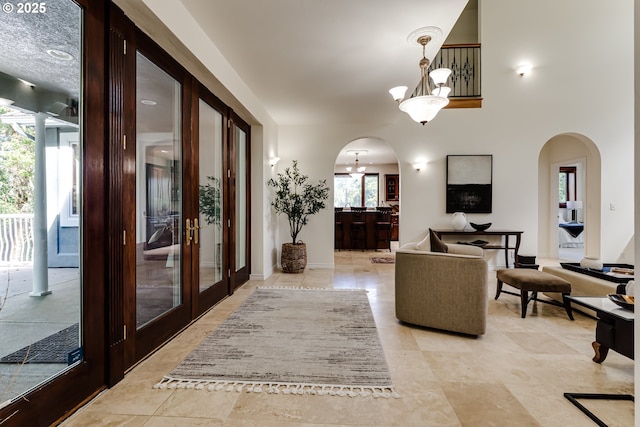 27161 Briggs Hill Rd, Eugene, OR 97405 - living room with arched walkways, french doors, a chandelier, and baseboards