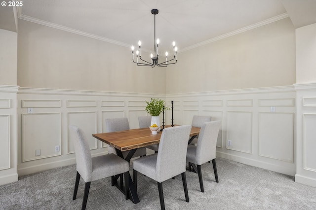 dining area with light carpet, crown molding, a chandelier, and a decorative wall