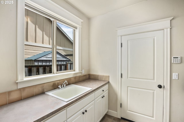 kitchen featuring white cabinets and a sink