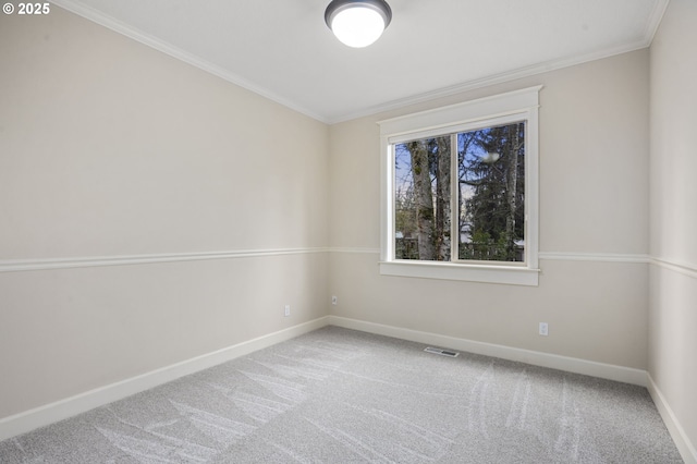 carpeted spare room with baseboards, visible vents, and crown molding