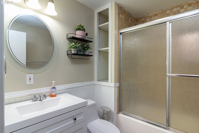 78613 Powerline Rd, Hermiston, OR 97838 - bathroom featuring vanity, built in shelves, shower / bath combination with glass door, and wainscoting