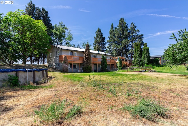 78613 Powerline Rd, Hermiston, OR 97838 - rear view of property featuring a wooden deck, a covered pool, and a lawn