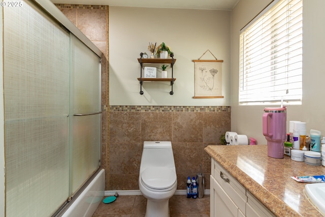 78613 Powerline Rd, Hermiston, OR 97838 - bathroom featuring vanity, tile walls, tile patterned floors, shower / bath combination with glass door, and a wainscoted wall