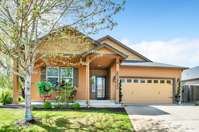 craftsman inspired home featuring an attached garage, driveway, fence, and a front lawn