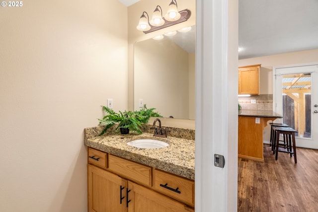 bathroom featuring decorative backsplash, vanity, and wood finished floors