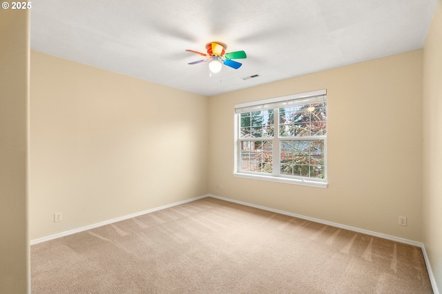 empty room with carpet flooring, visible vents, baseboards, and ceiling fan