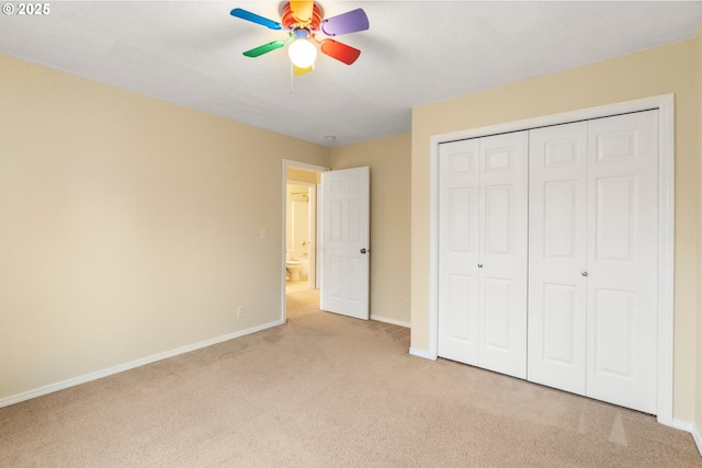 unfurnished bedroom with a closet, light colored carpet, baseboards, and ceiling fan