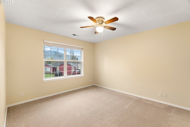 spare room featuring visible vents, baseboards, light colored carpet, and a ceiling fan