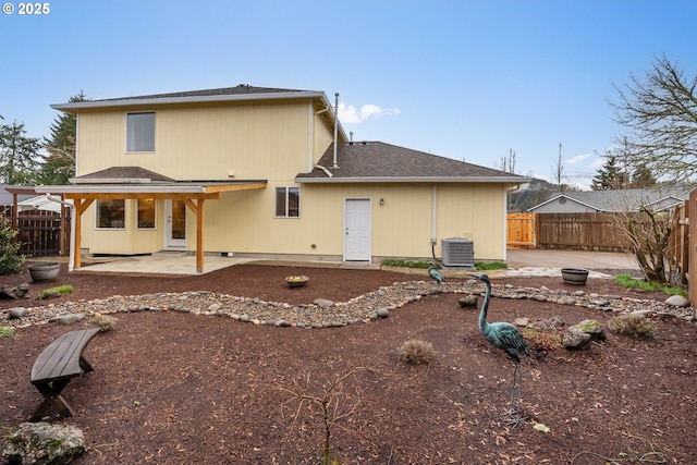 rear view of house with central air condition unit, a patio, roof with shingles, and fence