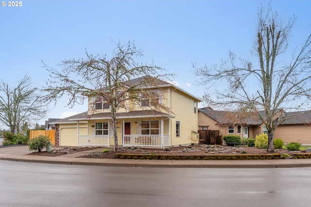 traditional home with a porch, an attached garage, and fence