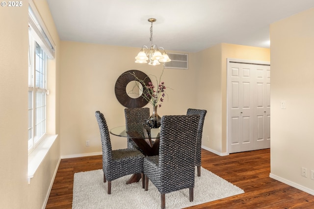 dining space with an inviting chandelier, dark wood-style floors, visible vents, and a wealth of natural light