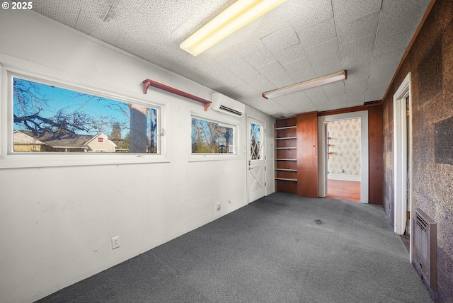 carpeted spare room featuring built in shelves and a wall mounted AC