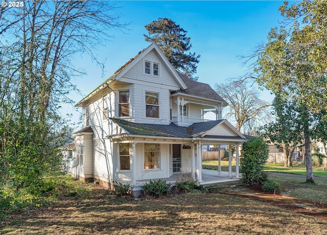 victorian house with a front lawn and covered porch