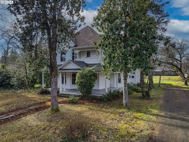 obstructed view of property featuring a front lawn and covered porch