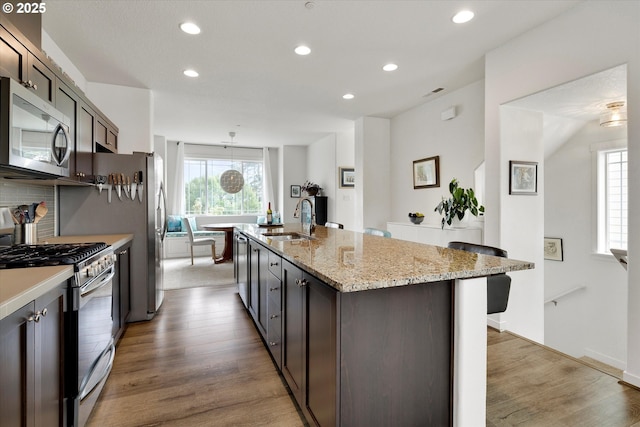28671 SW Orleans Ave, Wilsonville, OR 97070 - kitchen featuring stainless steel appliances, a sink, recessed lighting, light wood-style flooring, and a center island with sink