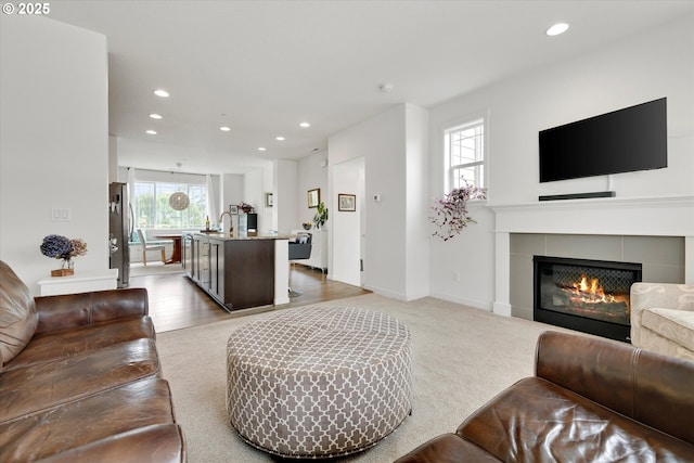 28671 SW Orleans Ave, Wilsonville, OR 97070 - living area with recessed lighting, a tiled fireplace, light carpet, and baseboards