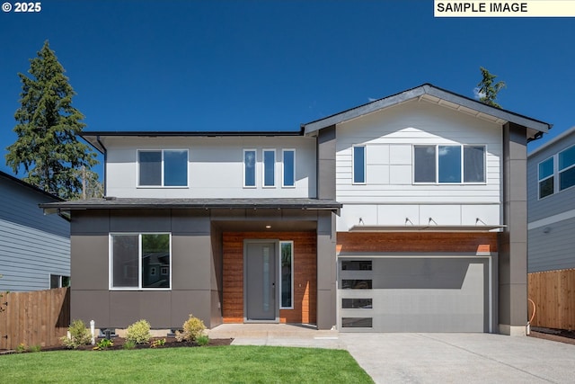 view of front of property featuring a front yard, concrete driveway, an attached garage, and fence