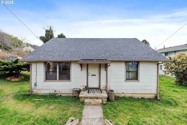 bungalow-style house featuring a front lawn and a shingled roof