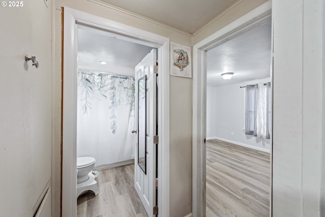 full bath featuring curtained shower, baseboards, toilet, and wood finished floors