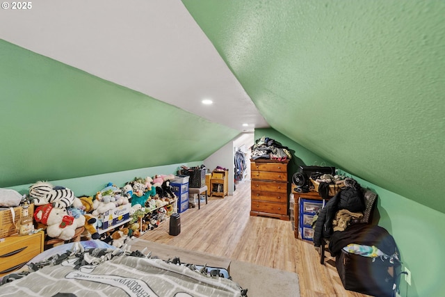 interior space featuring vaulted ceiling, recessed lighting, a textured ceiling, and wood finished floors