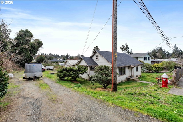 exterior space with fence, a yard, and dirt driveway