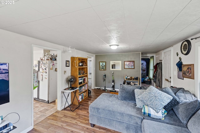 living area featuring baseboards and light wood-type flooring