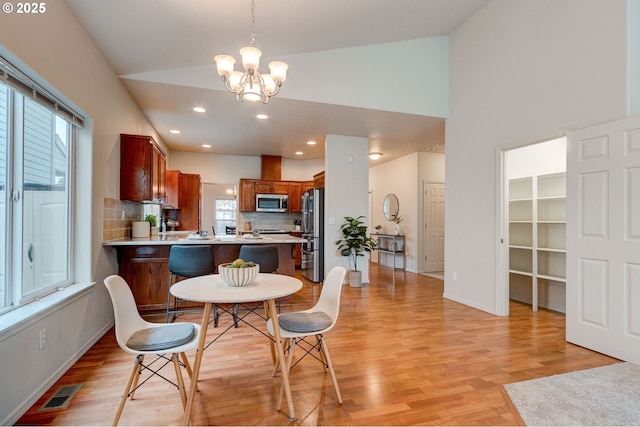 dining area featuring light wood finished floors, baseboards, visible vents, a notable chandelier, and recessed lighting