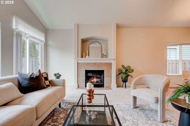 living room with vaulted ceiling, a fireplace, carpet flooring, and baseboards