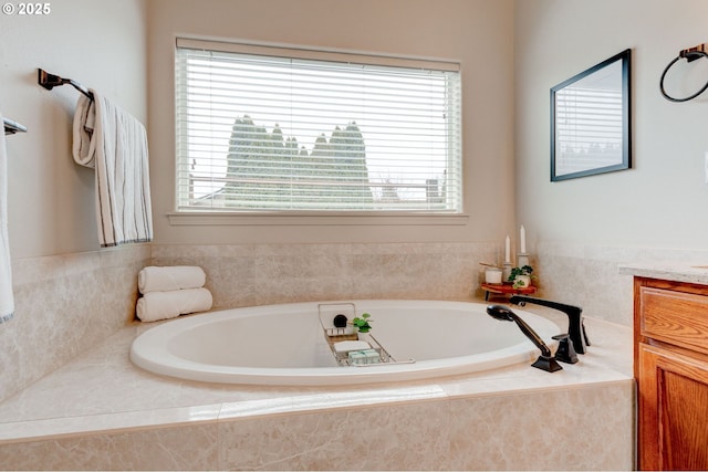 bathroom featuring a garden tub and vanity