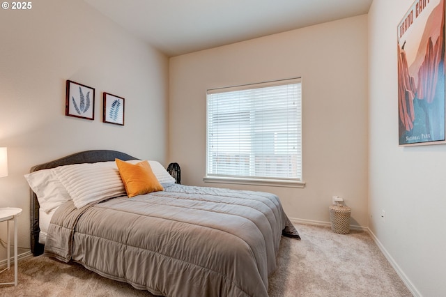 bedroom with baseboards and light colored carpet