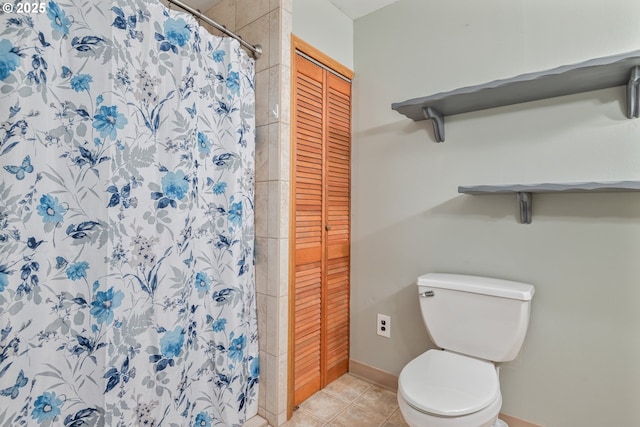 bathroom with a shower with shower curtain, tile patterned floors, and toilet