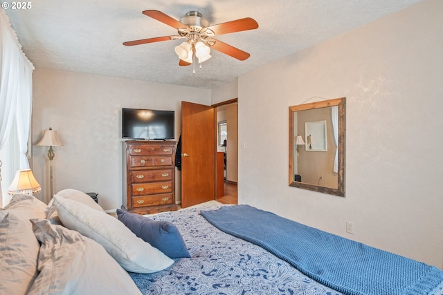 bedroom with ceiling fan and a textured ceiling