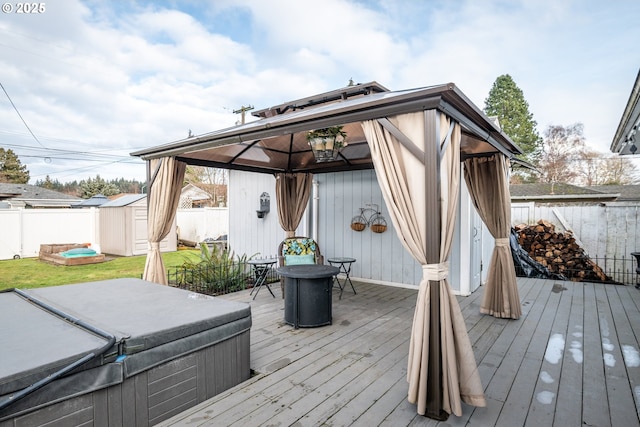 wooden deck with a shed, a gazebo, and a hot tub