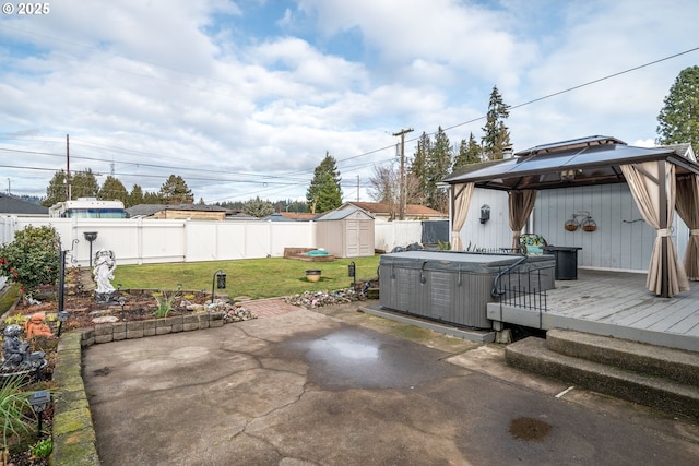 view of patio / terrace with a storage shed, a gazebo, a hot tub, and a deck