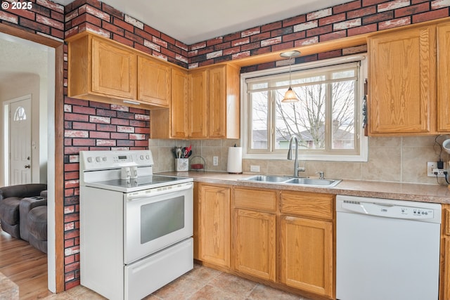 kitchen featuring sink, white appliances, hanging light fixtures, and decorative backsplash