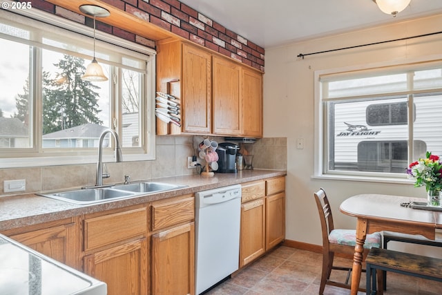 kitchen featuring decorative light fixtures, dishwasher, sink, decorative backsplash, and range