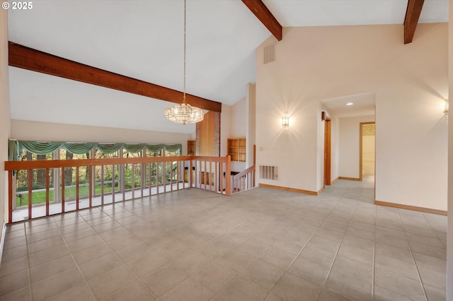 empty room with beam ceiling, visible vents, and baseboards