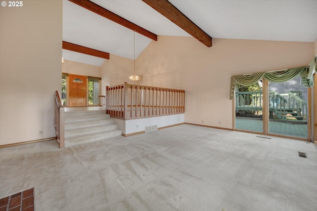 unfurnished living room featuring carpet floors, visible vents, high vaulted ceiling, and stairs