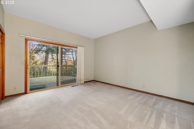 spare room with light carpet, visible vents, and baseboards