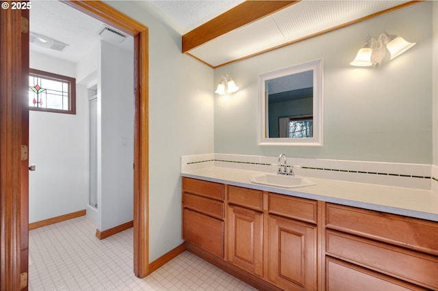 full bath with a stall shower, baseboards, visible vents, and vanity