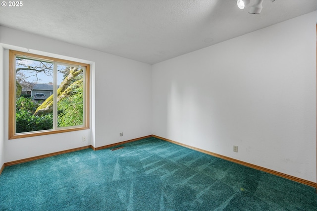 carpeted spare room featuring visible vents, a textured ceiling, and baseboards