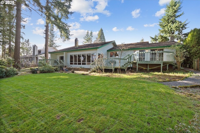 rear view of house with stairs, a chimney, a lawn, and a wooden deck