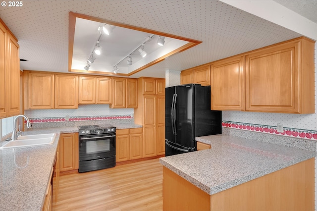 kitchen with black appliances, decorative backsplash, a sink, and light wood-style floors